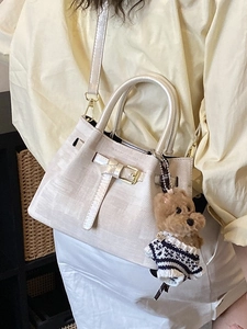 Beige strukturierte Mini-Eimertasche mit Teddybär-Anhänger und Goldbeschlägen