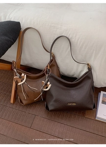 Detail of vintage matte leather tote bags in coffee and caramel with pony charms