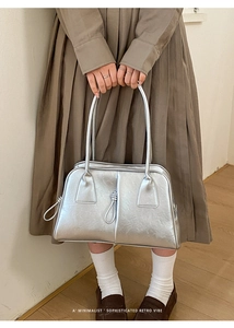 Close-up of silver retro handbag with knot rope detail and long shoulder handle