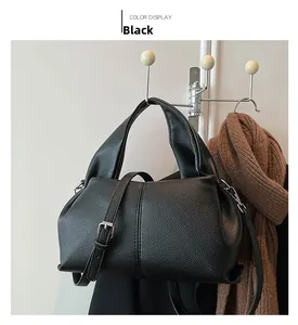 Detail of black lychee grain leather handbag with silver hardware on a wall hook