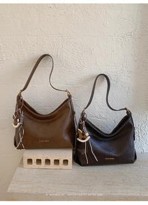 Detail of vintage hobo bags in dark brown and caramel leather with brand logo and tassels