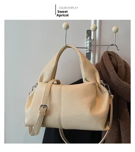 Detailed texture of apricot faux leather handbag with adjustable silver buckle strap