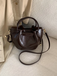 Dunkelbraune Beuteltasche aus Lackleder mit Kordelzug und goldener Hardware für Damen