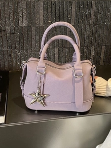 Lavender purple bowling bag with silver starfish charm against a black stone wall