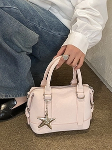 Pink matte leather bowling bag with star chain charm and twin handles shown by model