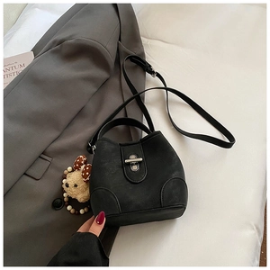 Detail of black matte bucket bag with silver twist lock and adjustable shoulder strap