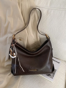 Dark brown faux leather hobo tote bag with PANTOOR logo and horse charm on a cozy background