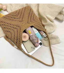 Detail of spacious beige woven tote bag with fringe accents and summer vacation essentials