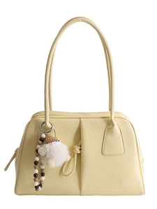 Elegant cream leather underarm bag with plush dwarf charm and beaded chain on white background