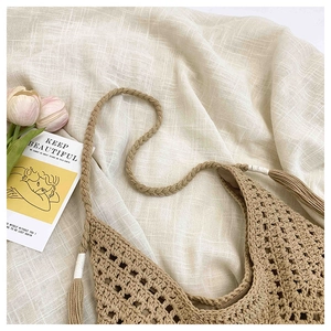 Close-up of khaki crochet beach bag featuring hollow mesh pattern and boho tassels