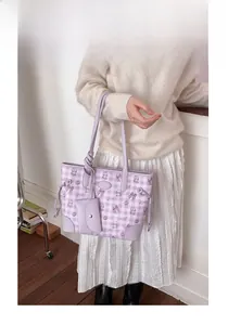 Détail du cabas en toile à carreaux violets avec motifs de chats et petite pochette