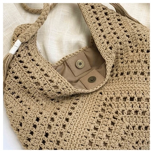 Detail of hand-woven straw bag with inner lining and antique bronze magnetic clasp