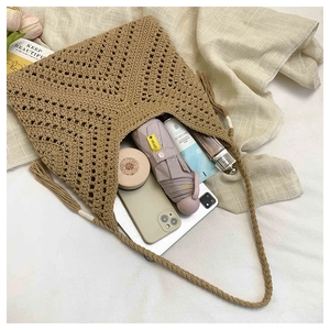 Flat lay showing large capacity interior of woven shoulder bag with daily essentials