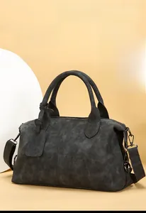 Detail of grey Boston handbag with matte leather texture and gunmetal hardware