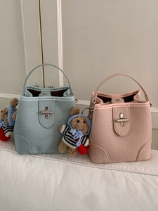 Litchi pattern bucket bags in pink and blue featuring cute bear charms and metal toggle