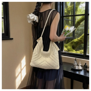 Detailed close-up of ivory crochet tote bag with fringe and braided shoulder strap