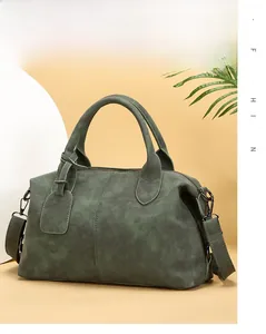 Detailed view of dark green retro Boston bag with textured leather and silver hardware