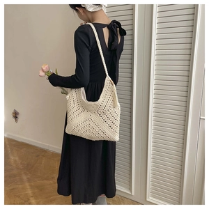 Detail of the woven texture on a minimalist cream crochet shoulder beach hobo bag