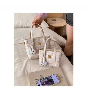 Pink and white checkered bucket bags with plush bunny charms in a cozy bedroom setting