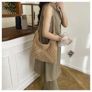 Close-up of woven straw shoulder bag featuring geometric hollow mesh and chunky straps