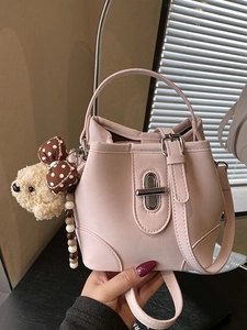 Elegant pink bucket bag with silver twist lock and cute plush bear charm for women
