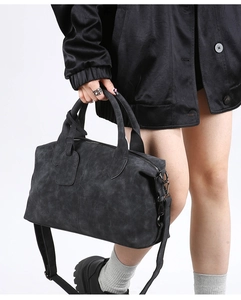 Close-up of matte charcoal boston bag with dual handles and adjustable shoulder strap