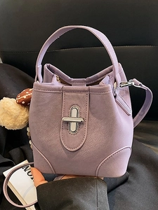 Chic purple leather bucket bag for women with matte texture and decorative pompom charm