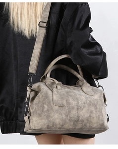Detail of retro smoke grey Boston bag with distressed leather texture and aged silver hardware