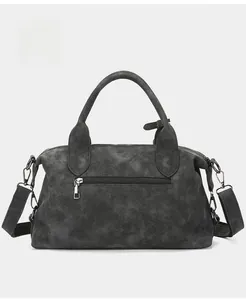 Detail view of charcoal gray suede handbag back with functional metal zipper pocket