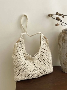 Bohemian off-white hollow woven beach bag with decorative tassels and hobo shoulder strap