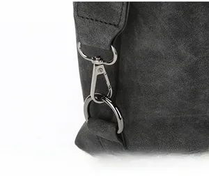 Close-up of gunmetal swivel hook and D-ring on dark gray frosted suede handbag