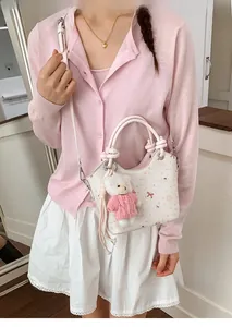 Detail of white bucket bag with pink ribbon bear print and cute teddy charm