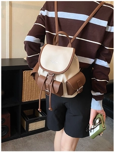 Detail view of a vintage contrast color leather backpack with functional metal buckles