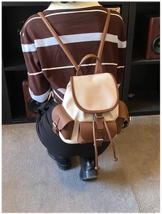 Detail of vintage cream and brown faux leather backpack with drawstring closure and pockets