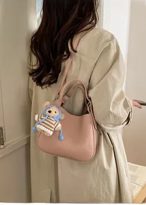 Chic lotus pink bucket bag with lychee texture leather and a cute plush bear pendant