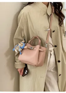Sac seau rose texture litchi avec fermoir en métal et charm d'ours rayé bleu