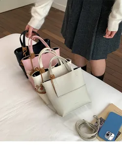 Detail view of small bucket bags in four colors with wooden horse charms and leather straps