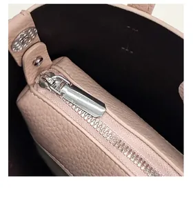 Internal view of pink lychee leather bucket bag with silver zipper and black lining