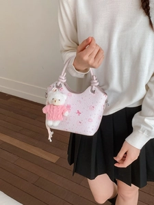 Chic pink bucket bag with bear and bow prints, featuring a plush bear charm and handles
