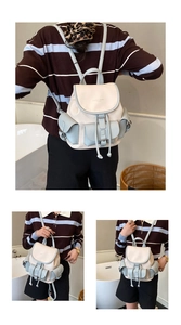 Detail of cream and light blue leather backpack with three front pockets and drawstring