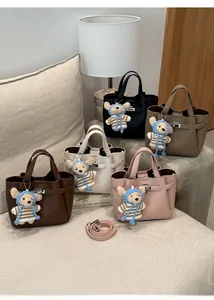 Détail de sacs à main en cuir grainé en cinq couleurs avec des breloques ours mignon