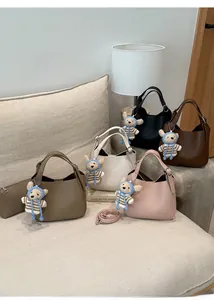 Detail of hobo bucket bags in five colors with lychee grain texture and bear charms