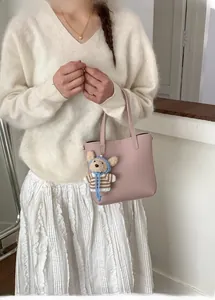 Pink lychee texture bucket bag with a cute bear charm styled on a model outfit