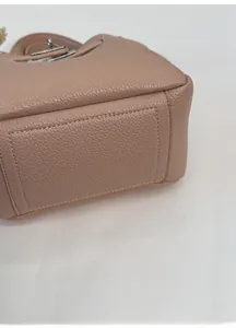 Gros plan sur la base large et les coutures de précision du sac seau rose en cuir