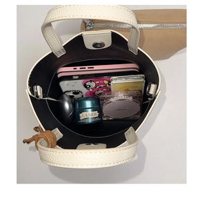 Detailed interior of a beige bucket bag showing storage space for daily essentials
