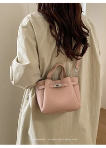 Détail du sac seau rose poudré montrant le cuir grainé et le fermoir métallique