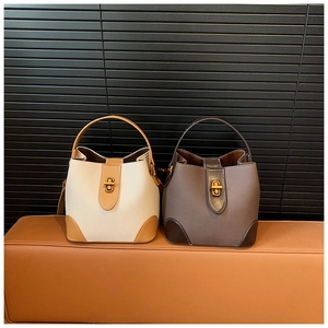 Detail view of contrast color bucket bags with lychee grain faux leather and gold hardware