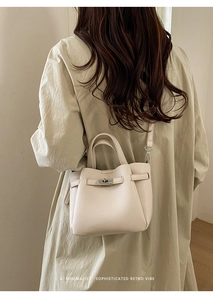 Détail du sac seau en cuir crème avec fermoir rotatif en métal et bandoulière chic