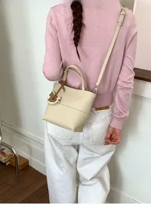 Back view of a chic cream lychee texture crossbody bag with a cute horse charm