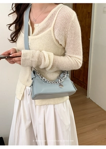 Dettaglio della borsa baguette in pelle azzurra con catena d'argento e ciondolo
